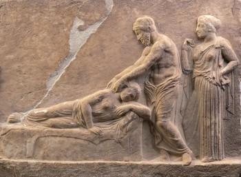 Μαρμάρινο αναθηματικό ανάγλυφο: Υπό το βλέμμα της Υγείας, ο Ασκληπιός θεραπεύει ασθενή κατά τη διάρκεια της εγκοίμησης στο Ασκληπιείο. Το ανάγλυφο χρονολογείται περίπου στο 400 π.Χ. και δόθηκε στην έκθεση από το Αρχαιολογικό Μουσείο Πειραιά.