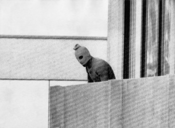 Ένας από τους τρομοκράτες του «Μαύρου Σεπτέμβρη» κοιτάζει από το μπαλκόνι του διαμερίσματος, όπου εννέα μέλη της ισραηλινής αποστολής κρατούνται όμηροι.